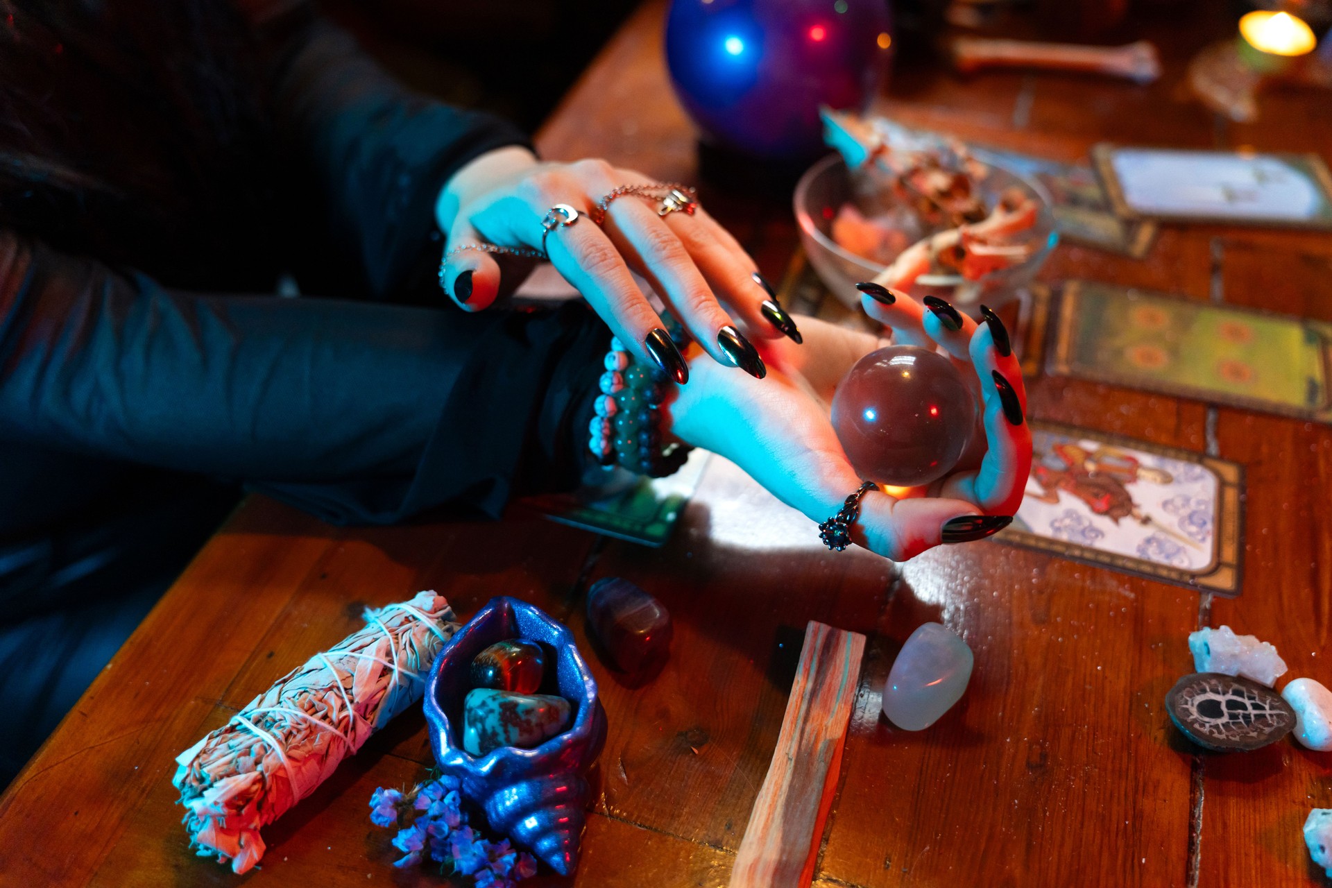 Fortune teller reading crystal ball predicting future using tarot cards and stones